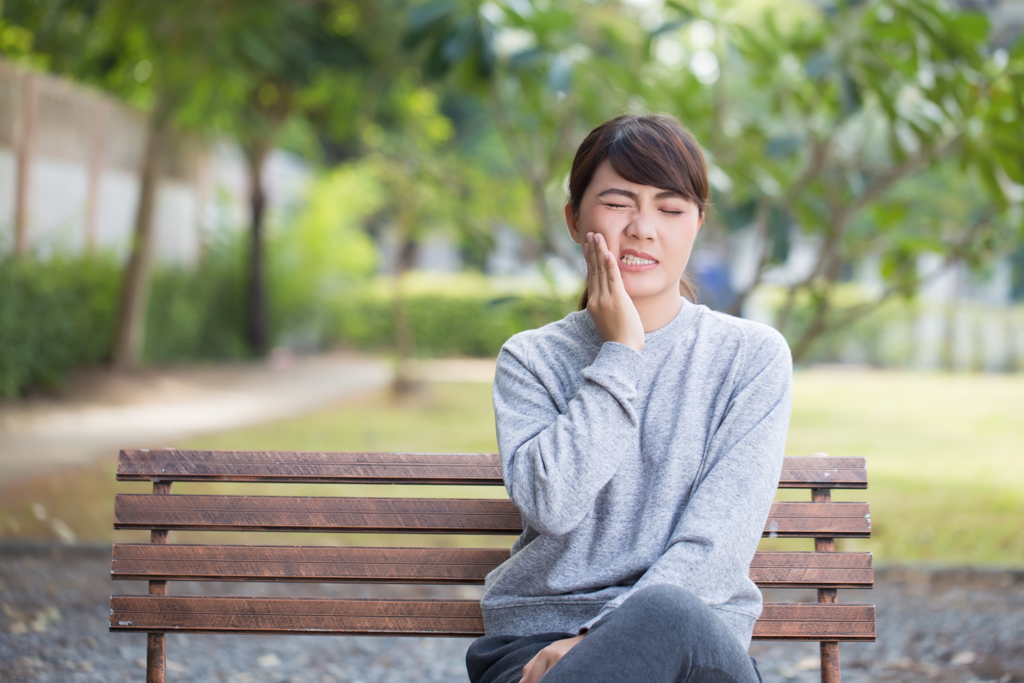 Woman on park bench with a toothache