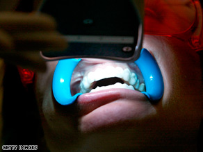 Ultraviolet light treatment, shown here at Smilestudio in London, England, is one way to whiten teeth.