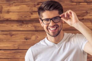 handsome young man in eyeglasses looking at camera and smiling