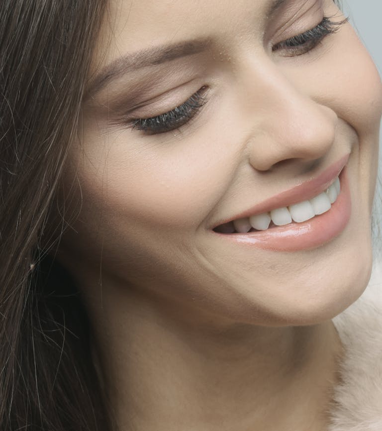 A beautiful close-up portrait of a smiling woman showcasing natural beauty and happiness.